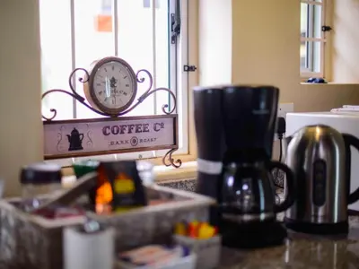 a coffee pot on a counter with a clock on it at Stay@Sparks Guesthouse in Lephalale