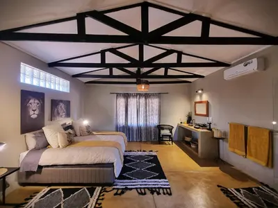 a bedroom with a bed and a desk in it at Ngalali Retreat in Grietjie Nature Reserve