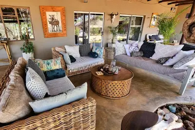a living room with couches and a table at Ngalali Retreat in Grietjie Nature Reserve