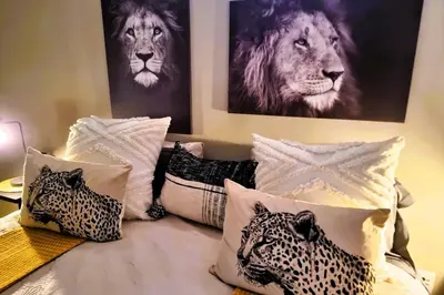 a bed with a bunch of pillows on it at Ngalali Retreat in Grietjie Nature Reserve
