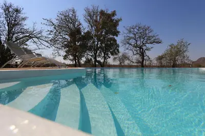 a swimming pool with a boat in the water at Ngalali Retreat in Grietjie Nature Reserve