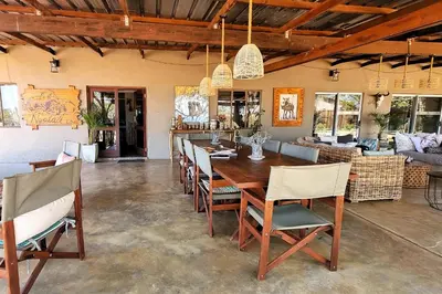 a dining room with a wooden table and chairs at Ngalali Retreat in Grietjie Nature Reserve