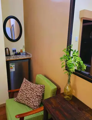 a living room with a green chair and a table at Kruger Dreams Lodge in Marloth Park