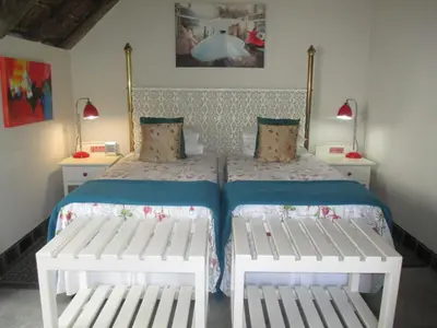 a bedroom with a bed with two white benches at Utopia in Africa Guest Villa in Nelspruit