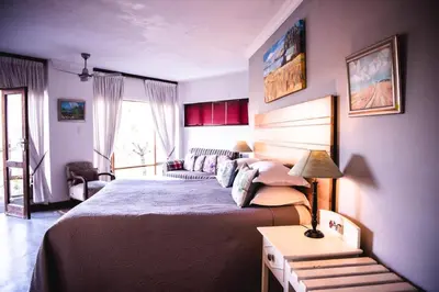 a bedroom with a large bed and a couch at Utopia in Africa Guest Villa in Nelspruit