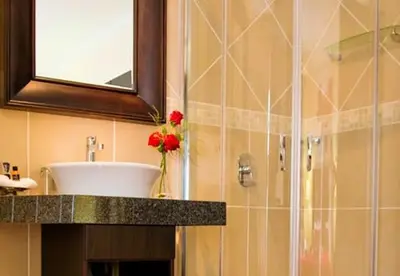 a bathroom with a sink and a glass shower at La Barune Guest House in Tzaneen