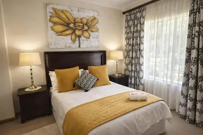a bedroom with a large bed and a window at La Barune Guest House in Tzaneen