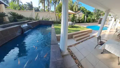 a swimming pool in a backyard with a house at La Barune Guest House in Tzaneen