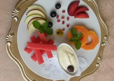 a plate of fruit and vegetables on a plate at La Barune Guest House in Tzaneen