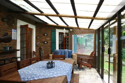 a screened in porch with a table and chairs at Mickey Finn in Dullstroom