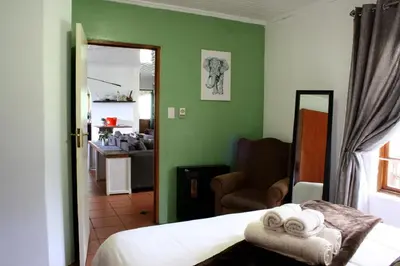 a bedroom with a bed and a living room at Mickey Finn in Dullstroom