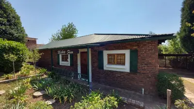 a small brick building with a sign on it at Mickey Finn in Dullstroom