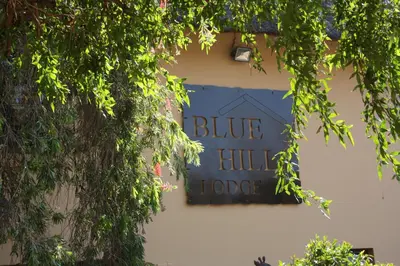 a blue hill lodge sign on the side of a building at Blue Hills Lodge in Midrand