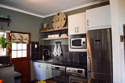 a kitchen with a refrigerator and a microwave at Ambassador Lodge in Dullstroom