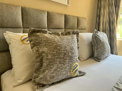 a bed with pillows and a pillow on it at Aerodrome Lodge and Conference Centre in Benoni