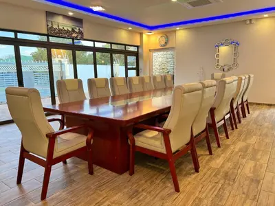 a conference room with a wooden table and chairs at Aerodrome Lodge and Conference Centre in Benoni