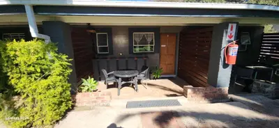 a patio with a table and a fire hydrant in front of a house at Livingwaters Self-Catering Accommodation in Ermelo