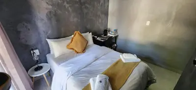 a small bedroom with a bed and a sink at Livingwaters Self-Catering Accommodation in Ermelo