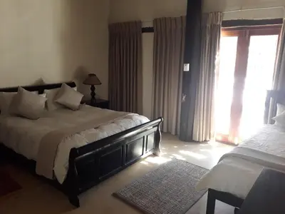 a bedroom with a large bed and a window at KweKwe Private Game Lodge in Marble Hall