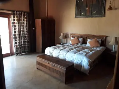 a bedroom with a large bed and a table at KweKwe Private Game Lodge in Marble Hall