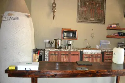 a kitchen with a table with a surfboard on the wall at KweKwe Private Game Lodge in Marble Hall