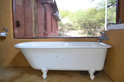 a white bath tub in a bathroom with a window at KweKwe Private Game Lodge in Marble Hall