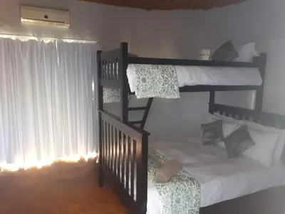 a bedroom with two bunk beds and a window at KweKwe Private Game Lodge in Marble Hall