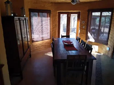 a dining room with a large wooden table and chairs at KweKwe Private Game Lodge in Marble Hall