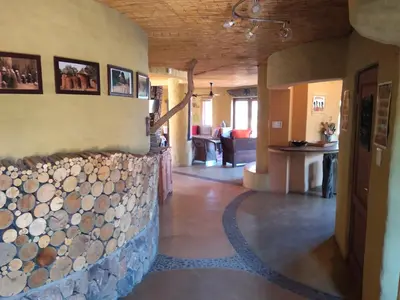 a living room with a wall of logs at KweKwe Private Game Lodge in Marble Hall