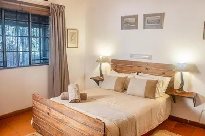 a bedroom with a large bed and a window at Owl House Marloth Park in Marloth Park