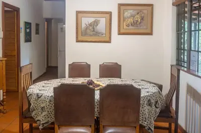 a dining room with a table and chairs at Owl House Marloth Park in Marloth Park
