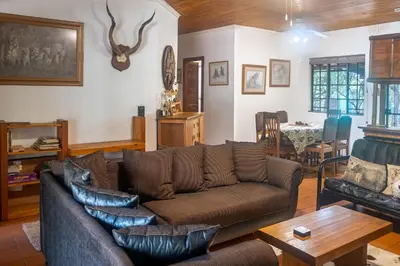 a living room with a couch and a table at Owl House Marloth Park in Marloth Park