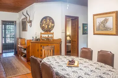 a dining room with a table and a table and chairs at Owl House Marloth Park in Marloth Park