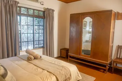 a bedroom with a large bed and a large window at Owl House Marloth Park in Marloth Park