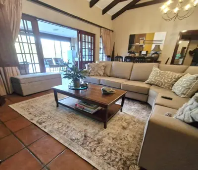 a living room with couches and a coffee table at Aviemore Lodge in Dullstroom