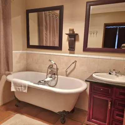 a bath tub and a sink in a bathroom at Aviemore Lodge in Dullstroom