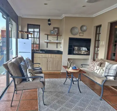 a living room with a couch and a table at Aviemore Lodge in Dullstroom