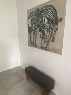 a painting of two zebras hanging on a wall at White River B & B in White River