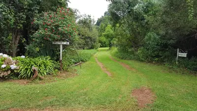 a dirt road with a sign in a garden at Wild Forest Inn in Graskop