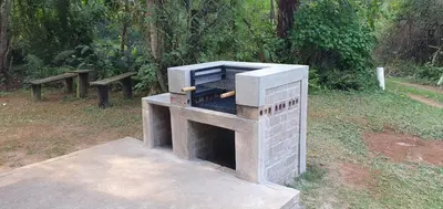 an outdoor oven in a park with two benches at Wild Forest Inn in Graskop