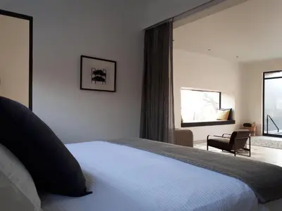 a bedroom with a bed and a large window at Ochre House in Marloth Park