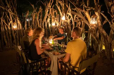 a group of people sitting at a table in a restaurant at Parsons Hilltop Safari Camp in Balule Game Reserve