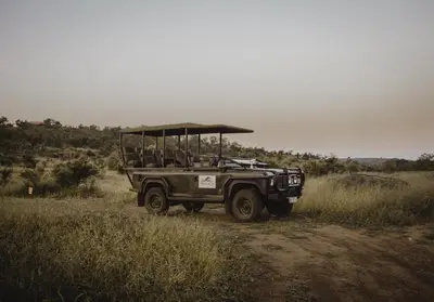 a jeep parked on a dirt road in a field at Parsons Hilltop Safari Camp in Balule Game Reserve