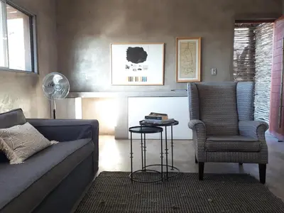 a living room with a couch and a chair and a table at Nextdoor Kruger in Marloth Park