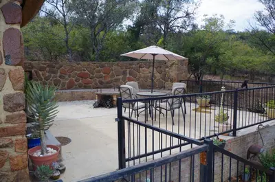 a patio with a table and an umbrella at Bosveldsig Cottages in Modimolle
