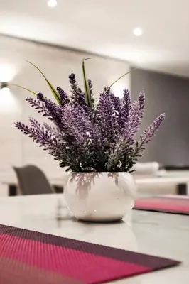 a white vase with purple flowers in it on a table at Cascades Guest Lodge in Nelspruit