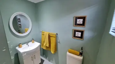 a bathroom with a sink and a mirror and a toilet at Arum Lily Guest Rooms in Pretoria