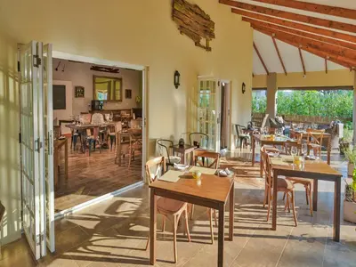 a dining room with wooden tables and chairs at Monkey Thorn Lodge & Wellness Spa - Adults Only in White River