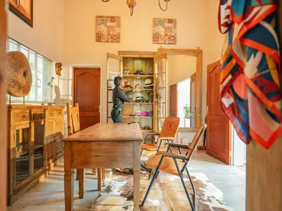 a man in a kitchen with a table and chairs at Monkey Thorn Lodge & Wellness Spa - Adults Only in White River
