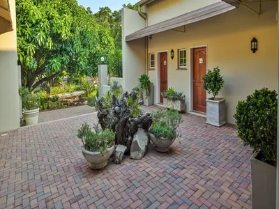 a building with a courtyard with potted plants in front of it at Monkey Thorn Lodge & Wellness Spa - Adults Only in White River
